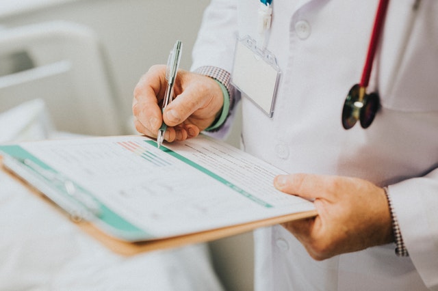 doctor writing notes on a clipboard