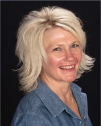 Julie Bahl headshot wearing a blue top in front of a black background