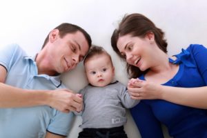 stock image of parents laying down with baby