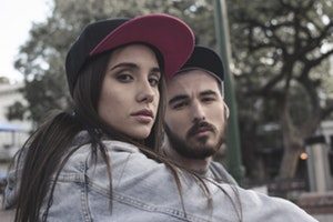 stock image of couple standing outside wearing hats