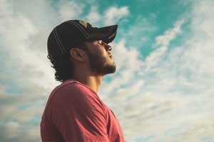 stock image of man standing outside with the sky behind him