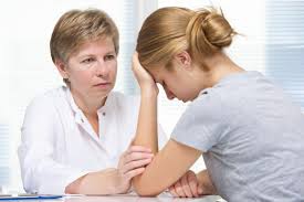 stock image of two women talking with one of them placing her head in the palm of one of her hands