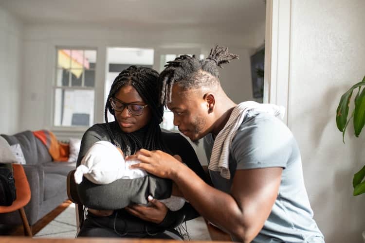 mom and dad holding newborn baby