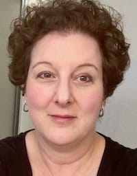 Therapist Lisa Volk indoors wearing a black top and earrings