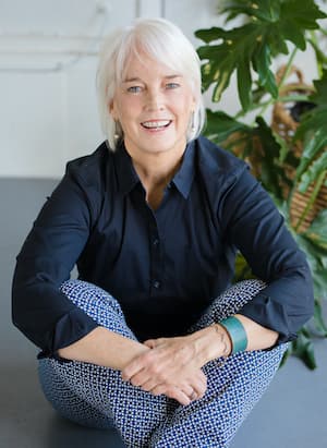 Therapist Jamie Brennan's professional headshot indoors with plants around her