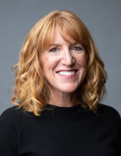 Headshot of Kimberly Nuffer in a photo studio in front of a gray background