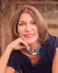 Headshot of Lynne McRae sitting outdoors while wearing a purple top