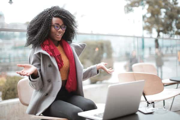 woman sitting outside with laptop on table