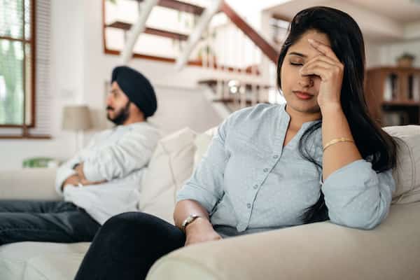 man and woman sitting on opposite sides of couch