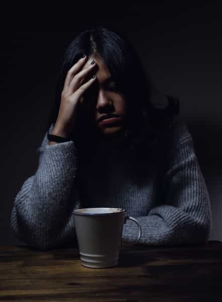 woman sitting at table with coffee cup in front of her