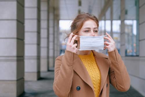 Woman putting on a mask during COVID