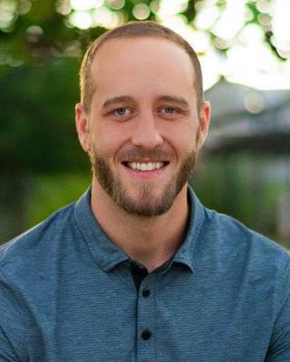 Therapist Tye Kemp wearing a blue shirt outdoors