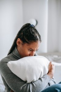 anxious young woman holding a pillow
