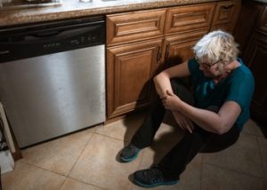 woman upset sitting on kitchen floor