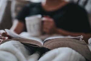 Person reading a book drinking tea