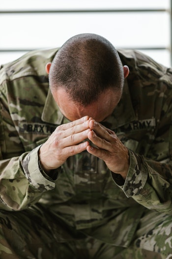 soilder stressed with hands on head